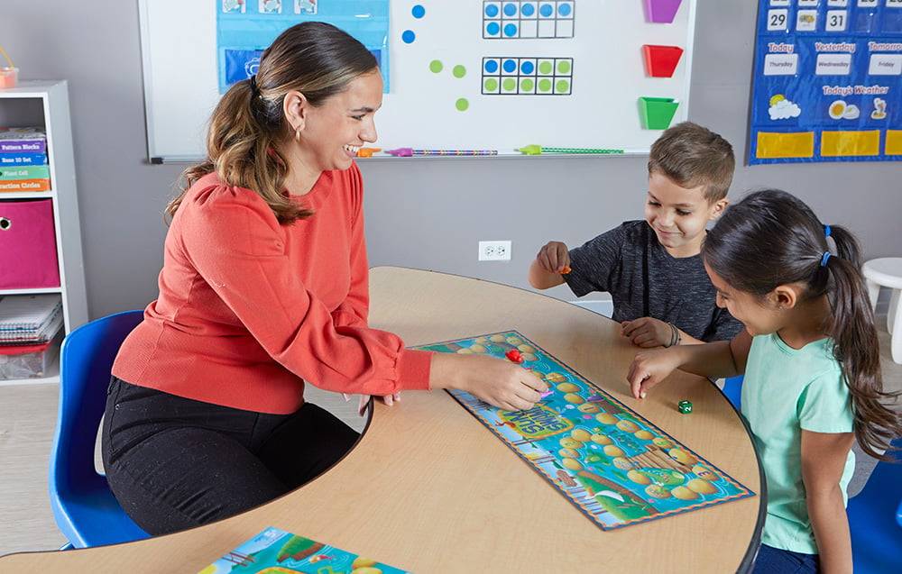 teacher explains board game rules to children