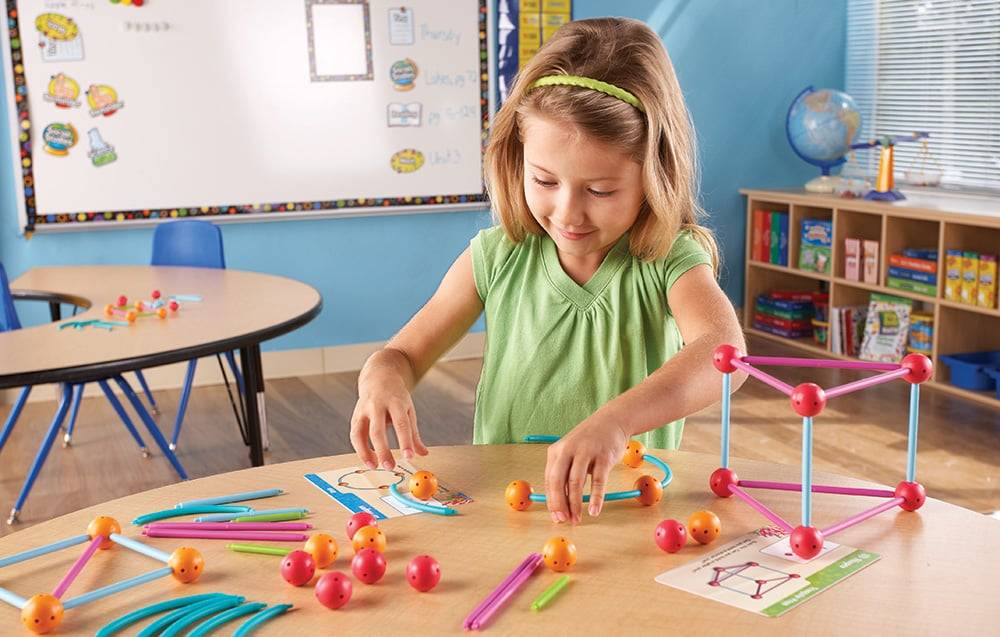 Girl arranging shapes from the building set